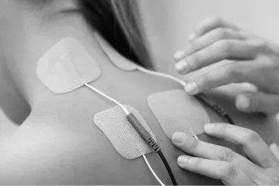 Electrical stimulation pads placed on a patient's upper back and shoulder